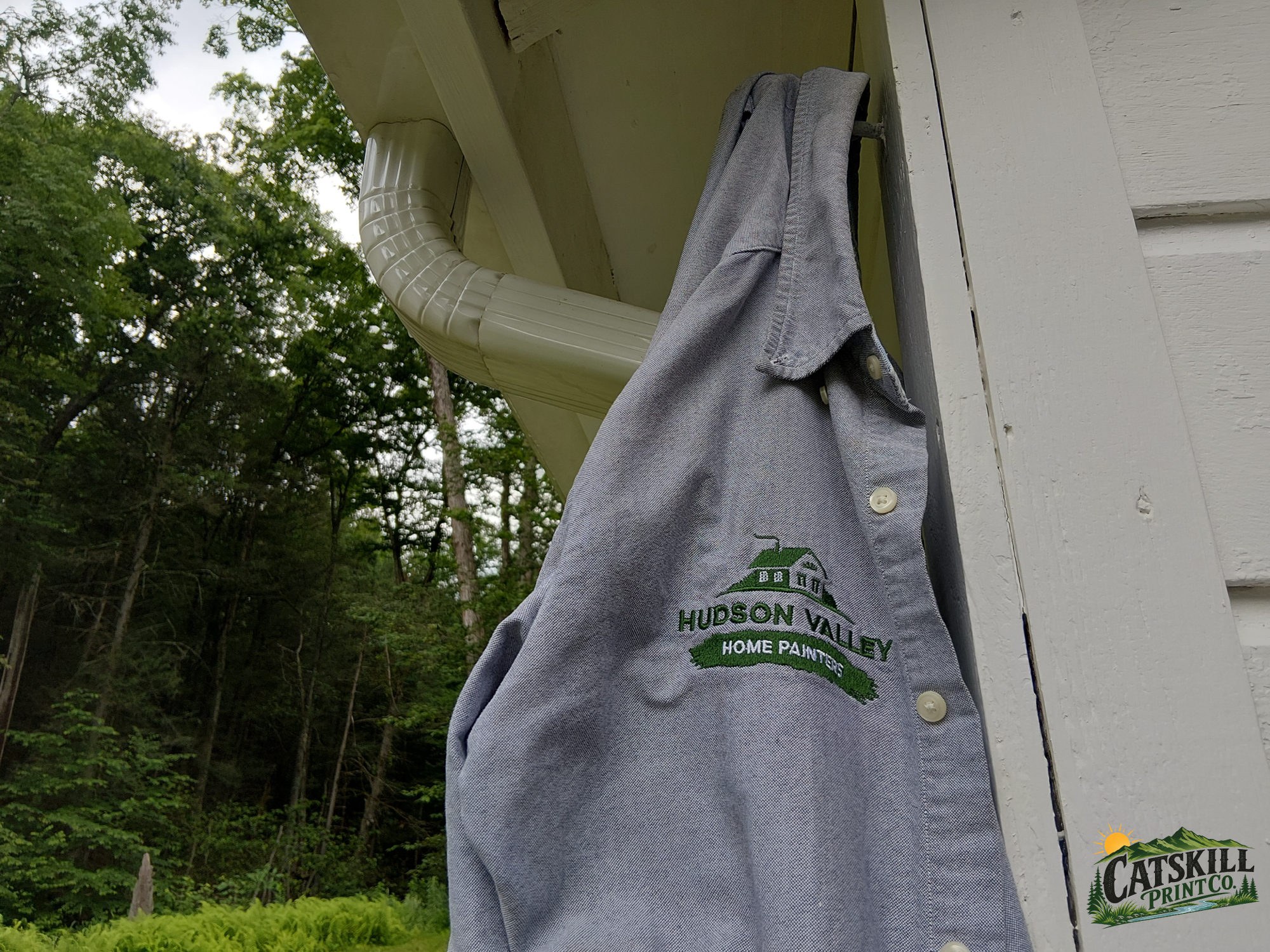 Custom embroidered Hudson Valley Home Painters work shirt photographed outdoors